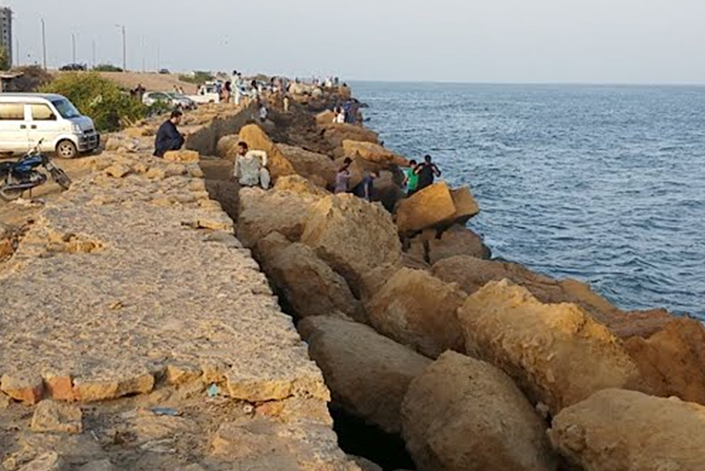 People walking on the sidewalks of Do Darya Road in Karachi, Pakistan.