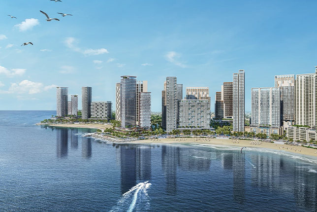 A tall high-rise building near the sea, with a clear view of the water and the sky.