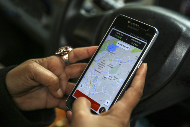 A smartphone displaying a digital payment app alongside a parked ride-hailing car as a public transport in Karachi.