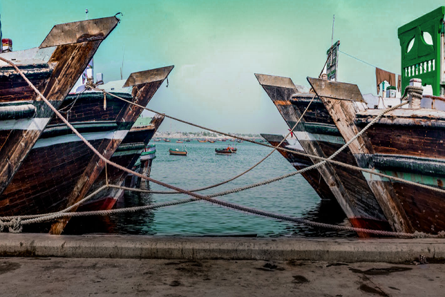 A group of anglers fishing from a pier at Port Qasim Karachi on a calm day.