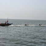 A scenic view of Do Darya Karachi at sunset with a person fishing near the shore.